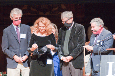 At the 2009 ceremony, Public Health Prize winner Dr. Elena Bodnar demonstrates her invention — a brassiere that, in an emergency, can be quickly converted into a pair of face masks, one for the brassiere wearer and one to be given to some needy bystander. She is assisted by Nobel laureates Wolfgang Ketterle (left), Orhan Pamuk, and Paul Krugman (right). PHOTO: Alexey Eliseev. Source: improbable.com
